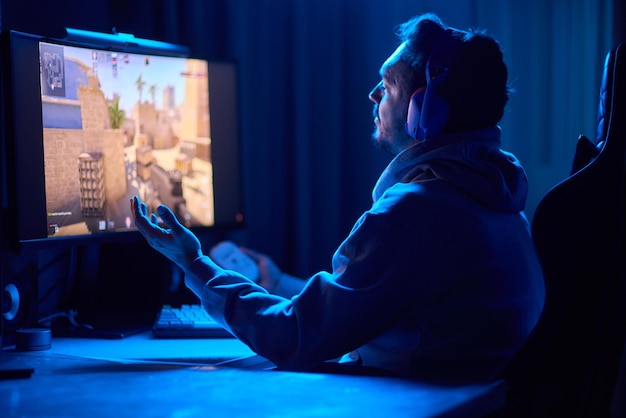 a coder is working late at night on a computer screen coding and using a smartphone app