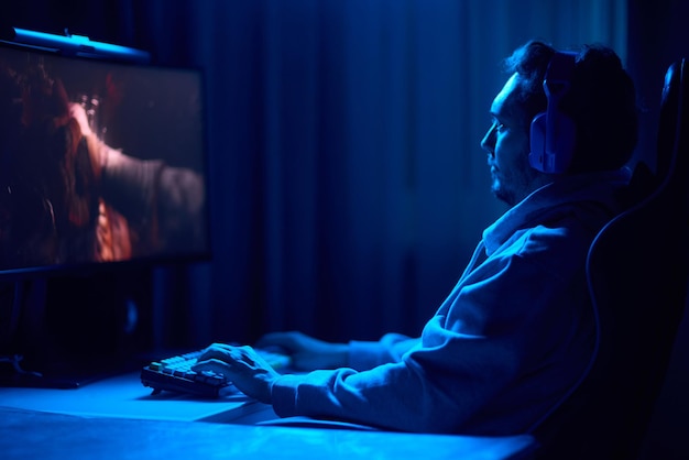 a coder is working late at night on a computer screen coding and using a smartphone app