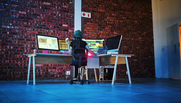 サイバーセキュリティプログラミングとデータ分析コードダッシュボードと夜に未来的なIoTとソフトウェアデータベースに取り組む女性の技術をコーディングするハッカー女性とコンピューターモニター