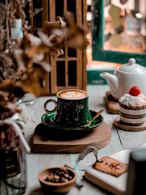 Cofee latte in tazza verde sul tavolo