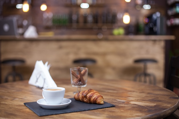 Coffe cup in a vintage coffee shop style. Croissant. Coffee aroma.