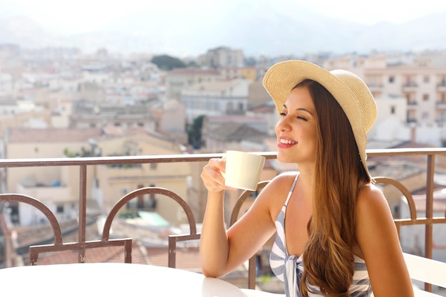 커피 광고. 아름 다운 여자 배경에 이탈리아 풍경과 카푸치노를 가져 가라. 광고 공간을 복사하십시오.