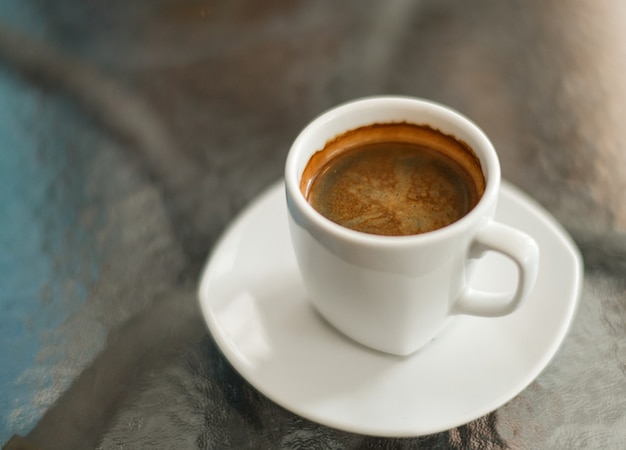 Coffee americano on the glass table, close up shot.