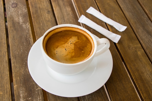 Coffee Americano in the white cup on the wooden table