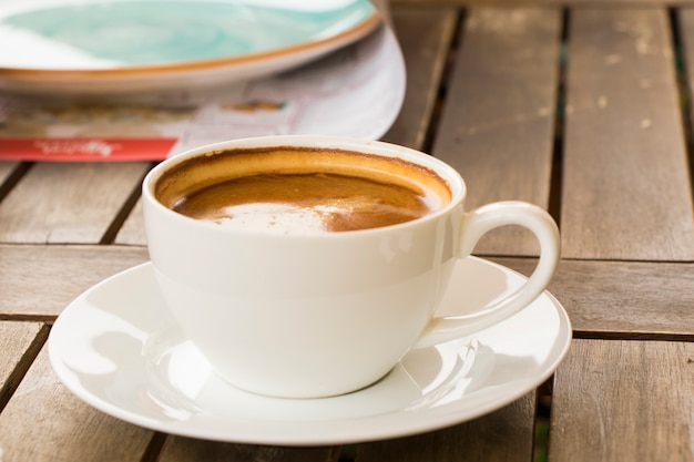 나무 테이블에 있는 흰색 컵에 커피 아메리카노