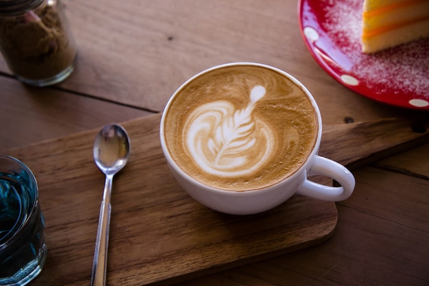 Foto caffè aroma latte art tazza sul tavolo in legno relax nella caffetteria caffetteria