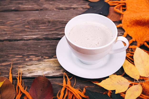 coffee and autumn leaves on a wooden background