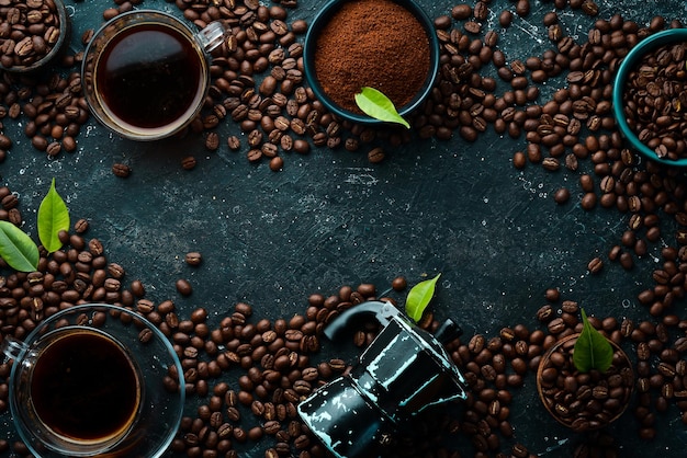 Coffee background Coffee in cups and coffee beans on a black stone background Top view Free space for text