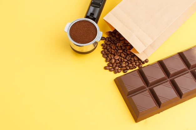 Coffee background. Coffee in a holder, coffee beans, bar of chocolate