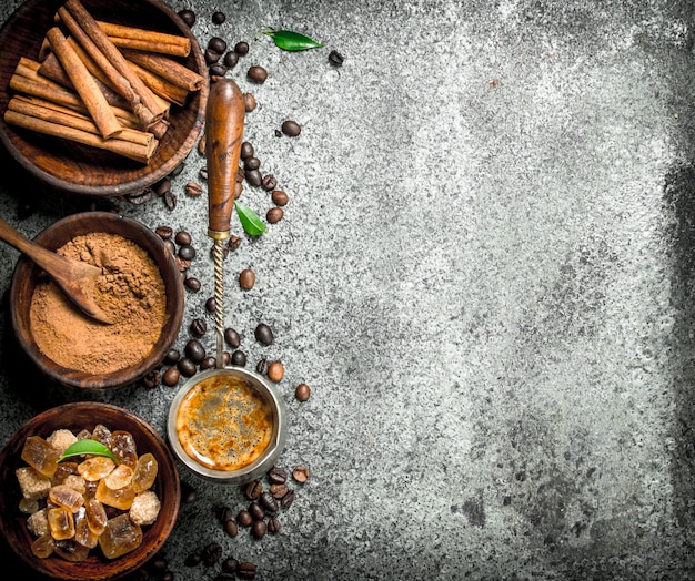 Coffee background Coffee in turkey with crystals of sugar, cinnamon and ground coffee on a rustic background