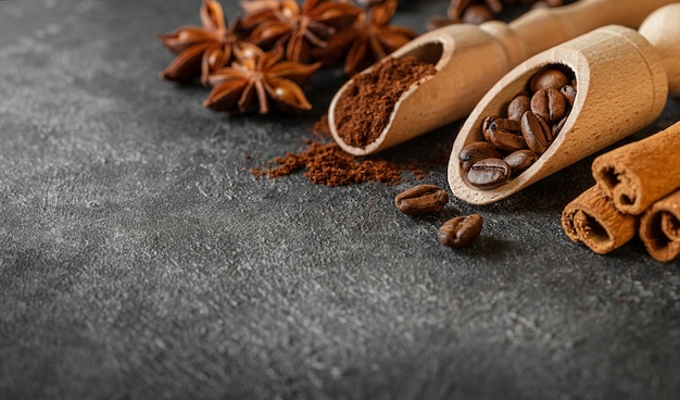 Coffee background with spices on dark background. Copy space, close up.