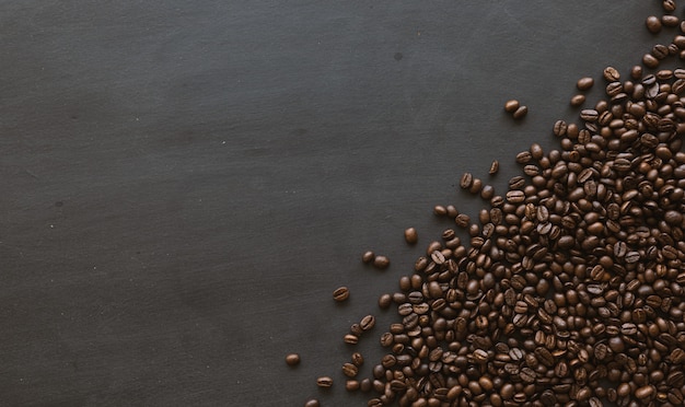 Foto chicco di caffè sul fondo di legno nero del pavimento