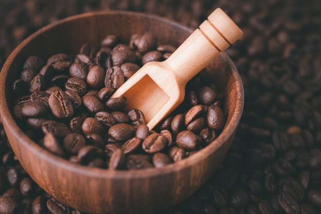 Кофе в зернах средней обжарки в деревянной миске.