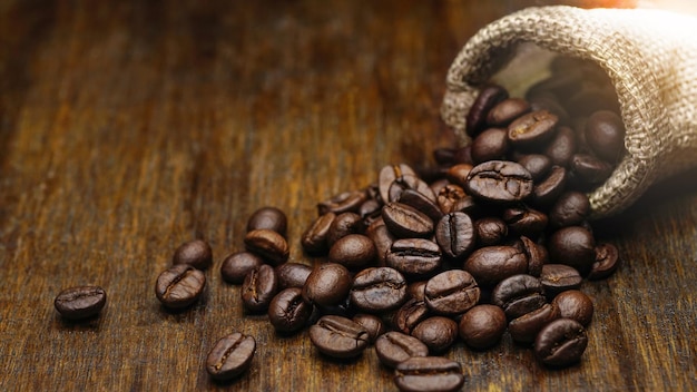 Coffee bean in sackcloth bag on wooden table