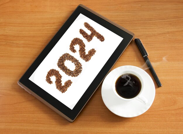 Premium Photo | Coffee beans and 2024 numbers in tablet pc with coffee