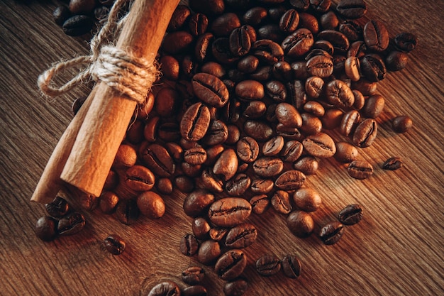 Coffee beans along with cinnamon on the table view from above fragrant coffee comes steam