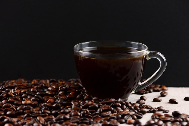 写真 テキスト用のスペースを持つ黒い背景にコーヒー豆とカップに入ったコーヒー