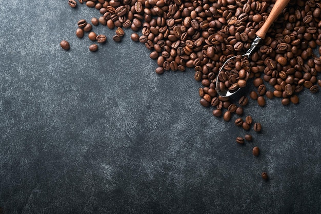 Фон кофейных зерен Жареные кофейные зерна на темном фоне черного камня Вид сверху Концепция кофе Макет