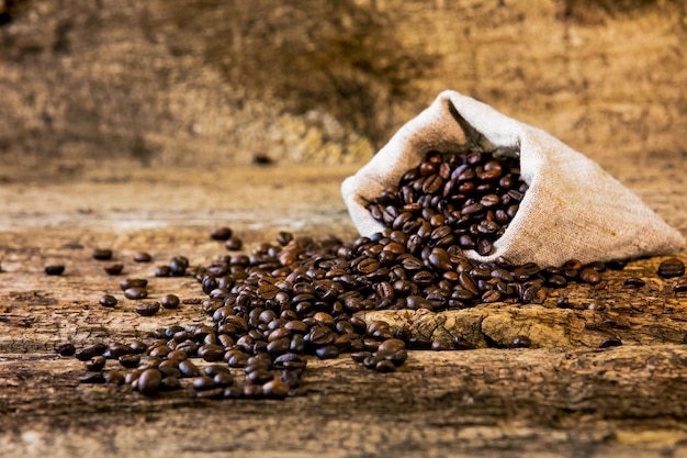 Coffee beans and bag on old wood background Fresh coffee beans and bag on old wood