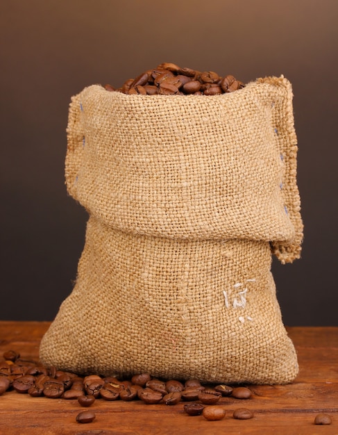 Coffee beans in bag on table on dark