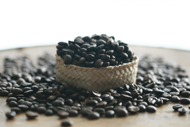 Coffee beans in the basket on wooden background