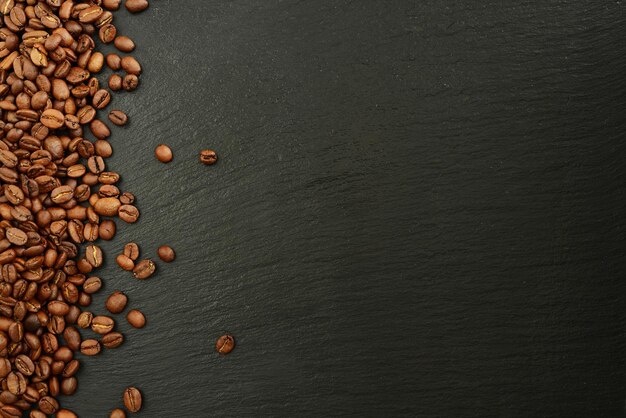 Coffee beans on black stone background Roasted Coffee beans black slate texture top view copy space