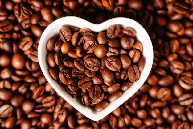 Coffee beans closeup focus on beans in white heart shape barista background coffee lover wallpaper