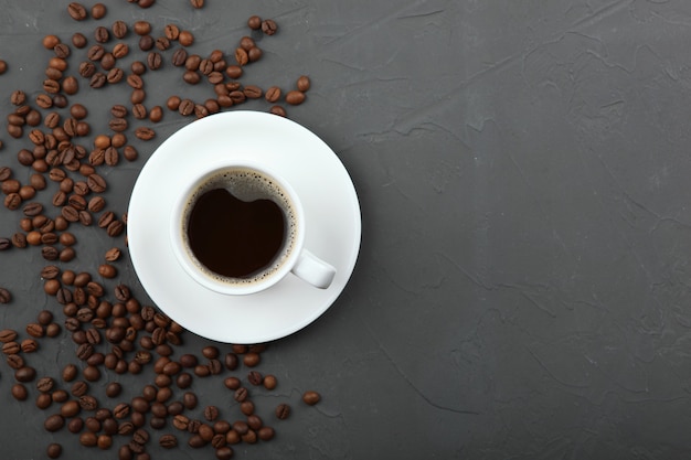 Coffee beans and coffee cup on colored background with place for text