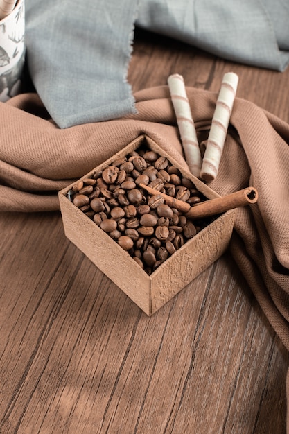 Coffee beans and connamons on box on wooden table