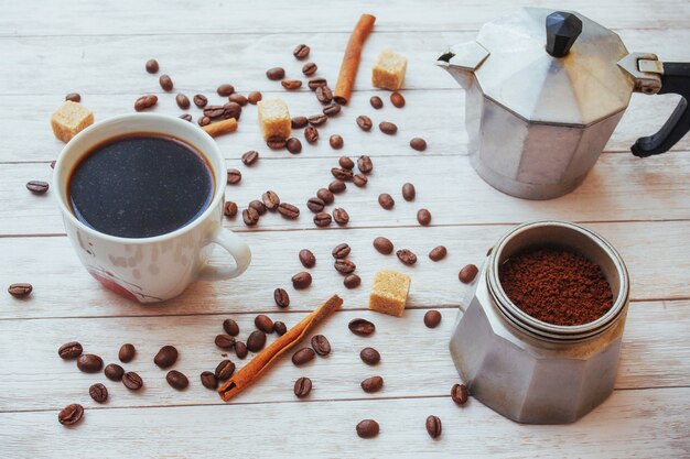 Coffee beans and cup of coffee on table on 