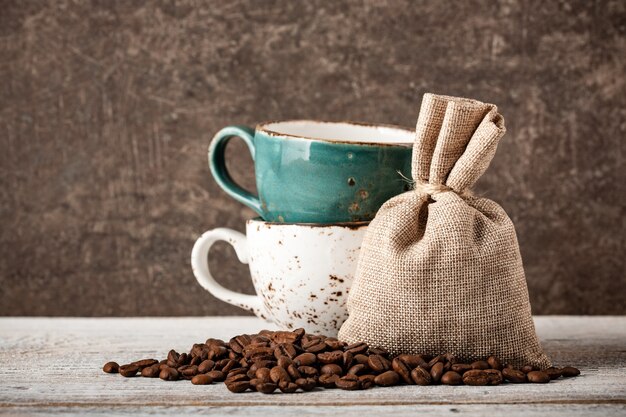 Coffee beans and cups on wooden table