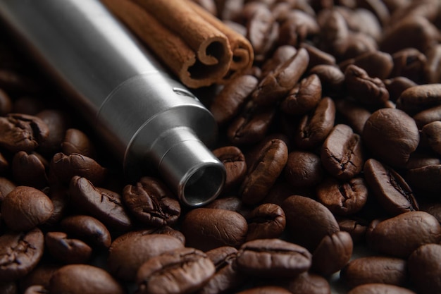 Coffee beans, E-cigarette and canella . Coffee and cinnamon flavored vape juice concept