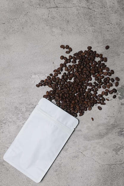 Coffee beans and eco packaging isolated on gray background.