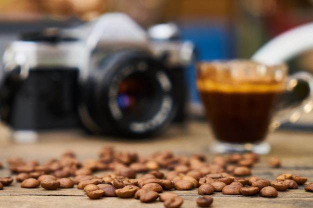 Coffee beans, espresso and retro film camera on the table