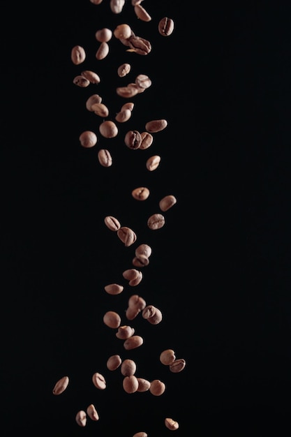 暗い背景に飛行中のコーヒー豆