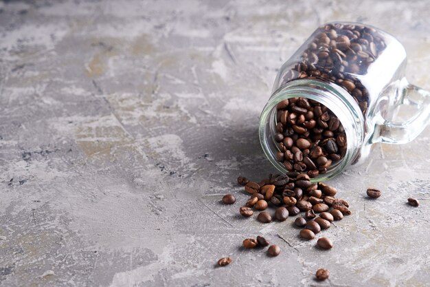 Coffee beans in a glass jar on a gray table