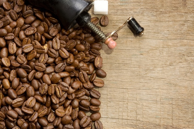 Coffee beans and grinder with copy space of wood texture