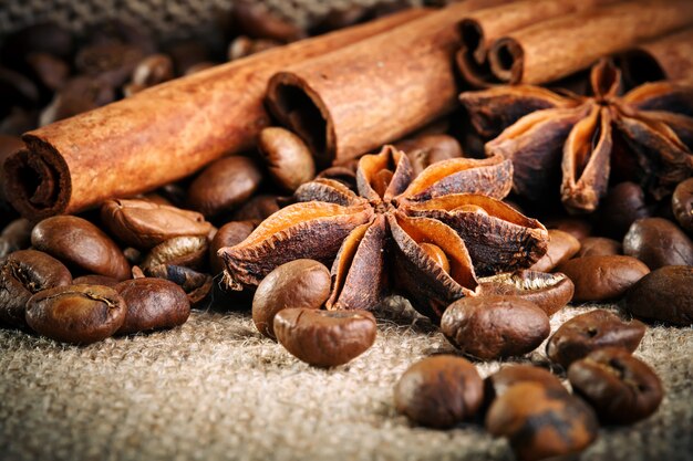 Coffee beans, ground coffee and cinnamon on burlap.