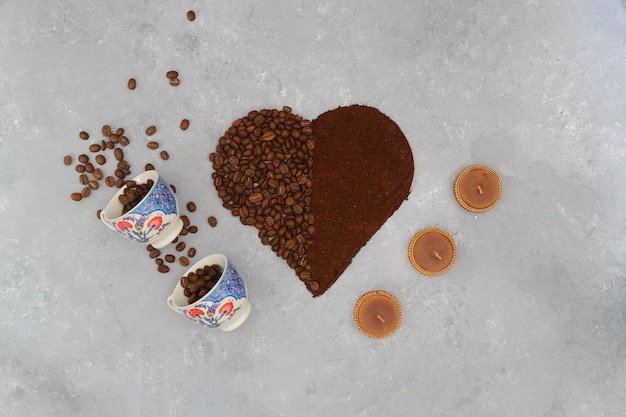 Coffee beans and ground coffee in wooden spoons on brown background With pot cup and grinder