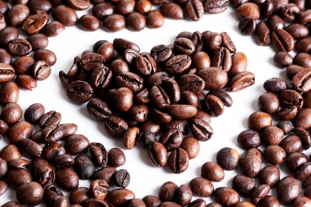 Foto chicchi di caffè a forma di cuore sfondo bianco