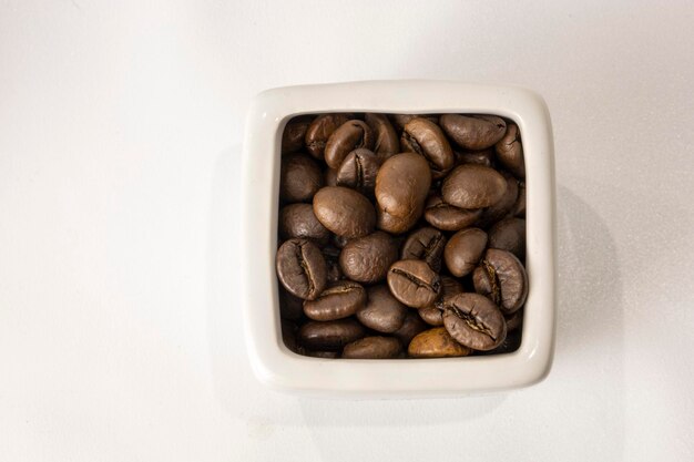 Coffee beans in jugs on a white background