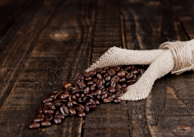Chicchi di caffè in panno di tela sul bordo di legno