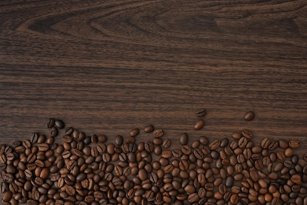 写真 茶色の木の背景に木製のテーブルの上のコーヒー豆