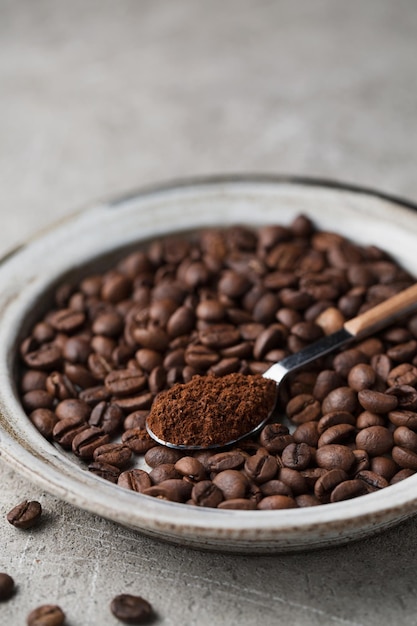 Coffee beans on a plate A spoon with ground coffee Arabica Macro photography in food photography