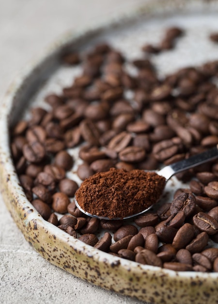 皿の上のコーヒー豆挽いたコーヒーのスプーンアラビカ食品写真のマクロ写真