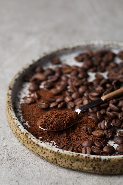 Coffee beans on a plate A spoon with ground coffee Arabica Macro photography in food photography