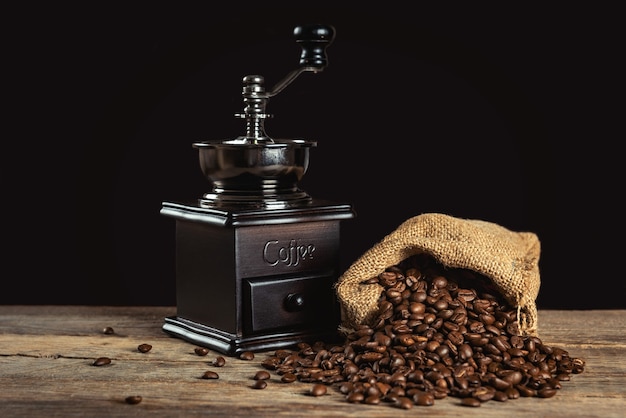 Chicchi di caffè e macinacaffè manuale retrò sul tavolo di legno