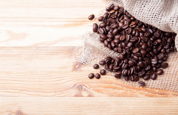 Coffee beans and rusty bag background. Top view