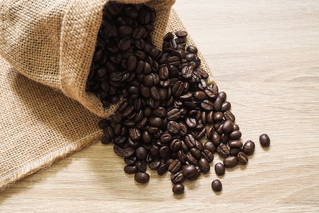 Coffee beans in sacks on wooden background