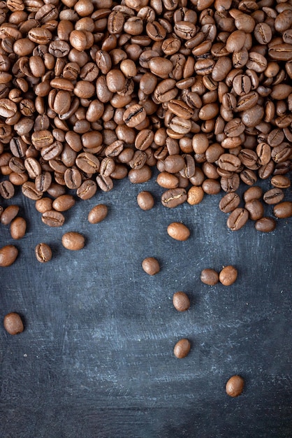 Coffee beans scattered over gray background, food background